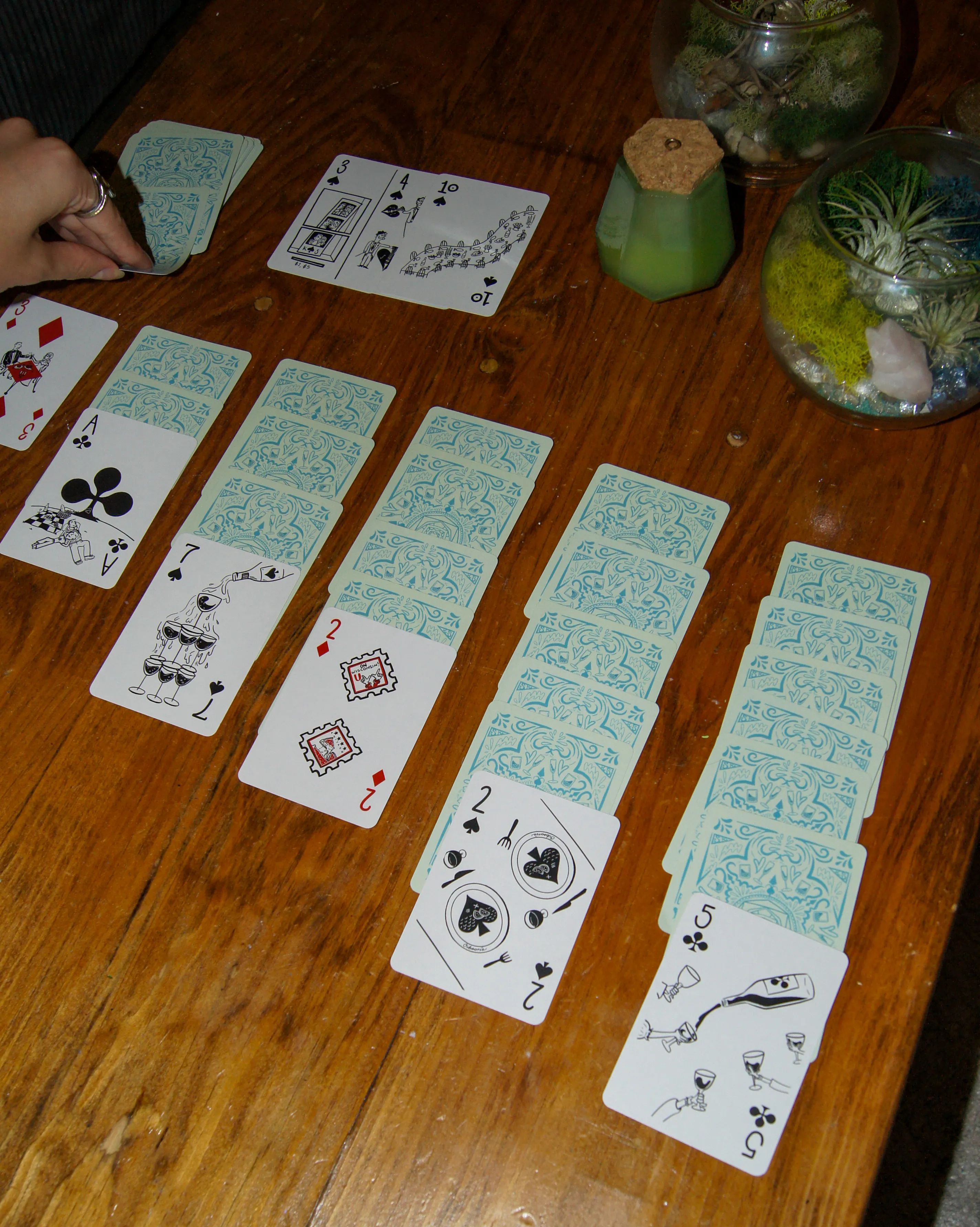The deck dealt into a solitaire spread, showing the pale blue patterned card backs alongside face-up illustrated cards.